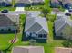 Bird's-eye view of a house with a gray roof, green lawns, and a screened-in patio, nestled in a tranquil neighborhood at 4712 St Andrews Arc, Leesburg, FL 34748