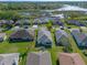 Scenic aerial view of a residential neighborhood with a beautiful lake and lush landscaping at 4712 St Andrews Arc, Leesburg, FL 34748