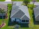 Elevated perspective of a home showing its gray roof, landscaping, screened-in patio, and inviting outdoor spaces at 4712 St Andrews Arc, Leesburg, FL 34748