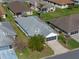Aerial view of a charming home featuring a gray roof, lush landscaping, and well-maintained lawns at 4712 St Andrews Arc, Leesburg, FL 34748