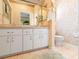 Bright bathroom featuring a double vanity with ample counter space and storage, plus a convenient toilet area at 4712 St Andrews Arc, Leesburg, FL 34748