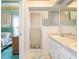 Bright bathroom featuring a walk-in shower, double vanity, and neutral tones, with a view to an adjacent bedroom at 4712 St Andrews Arc, Leesburg, FL 34748