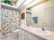 Bright bathroom featuring double sinks, a shower with a beach-themed curtain, and ample lighting at 4712 St Andrews Arc, Leesburg, FL 34748