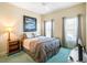 Comfortable bedroom with soft lighting, two windows, and a decorative painting above the bed at 4712 St Andrews Arc, Leesburg, FL 34748
