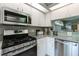 Close-up of the kitchen featuring stainless steel appliances, white cabinetry, and a functional layout for cooking at 4712 St Andrews Arc, Leesburg, FL 34748