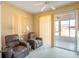 Comfortable living room featuring plush recliners and sliding glass doors to a screened porch at 4712 St Andrews Arc, Leesburg, FL 34748