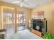 Cozy living room with sliding glass doors, a ceiling fan, and a media center with a TV at 4712 St Andrews Arc, Leesburg, FL 34748