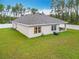 Backyard featuring a well-maintained lawn, white fence, and covered patio space at 4923 Sw 166Th Loop, Ocala, FL 34473