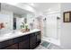 Bright bathroom boasts double sinks, dark cabinetry, and a walk-in shower at 4923 Sw 166Th Loop, Ocala, FL 34473