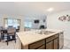 Open-concept kitchen island with stainless steel sink and seating, connecting to the living and dining areas at 4923 Sw 166Th Loop, Ocala, FL 34473