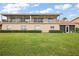 Two-story home with covered balcony that overlooks a lush lawn surrounded by garden hedges at 5359 Compass Pt, Oxford, FL 34484