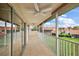 View of a tiled balcony with sliding glass doors and white railings overlooking a green lawn and other buildings at 5359 Compass Pt, Oxford, FL 34484