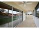 A spacious tiled balcony with large sliding glass doors and white railings that provide views of the surrounding property at 5359 Compass Pt, Oxford, FL 34484