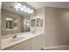 Well-lit bathroom featuring double sinks, ample counter space, and a large mirror at 5359 Compass Pt, Oxford, FL 34484