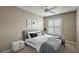 This bedroom features a neutral color palette, a ceiling fan, and a large window for natural light at 5359 Compass Pt, Oxford, FL 34484