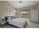 Comfortable bedroom featuring a large bed, sliding glass door to the balcony, and neutral tones at 5359 Compass Pt, Oxford, FL 34484