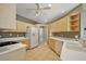 Spacious kitchen featuring tile flooring, light countertops and wooden cabinetry, and modern appliances at 5359 Compass Pt, Oxford, FL 34484