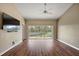 Spacious living room with hardwood flooring, neutral wall paint, ceiling fan and a sliding glass door leading to the outside at 5359 Compass Pt, Oxford, FL 34484