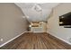 A spacious living room with wood flooring, an open layout, and a large flat-screen TV at 5359 Compass Pt, Oxford, FL 34484