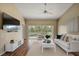 Bright living room with hardwood flooring, neutral wall paint and a sliding glass door with a view of the trees at 5359 Compass Pt, Oxford, FL 34484