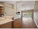 Open floor plan between the living room and kitchen with hardwood flooring, neutral wall paint and a sliding glass door at 5359 Compass Pt, Oxford, FL 34484