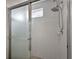 Shower with chrome-framed glass door, white tile surround, and adjustable shower head at 5359 Compass Pt, Oxford, FL 34484