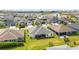 Picturesque aerial shot of a neighborhood, with charming homes and verdant lawns, set against a lake backdrop at 5978 Conley Ct, The Villages, FL 32163
