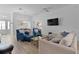 Bright living room with blue armchairs and a sectional couch, open to the dining area at 5978 Conley Ct, The Villages, FL 32163
