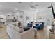 Open-concept living room showcasing tile floors, modern decor, and a seamless flow to the kitchen and dining area at 5978 Conley Ct, The Villages, FL 32163