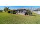 A luscious, green backyard shows the screened patio, great for entertaining at 6083 Delphina Loop, The Villages, FL 32163