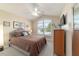 Cozy bedroom with a vaulted ceiling, a large window, and a comfortable queen-size bed with earth-tone bedding at 6083 Delphina Loop, The Villages, FL 32163