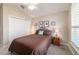 Comfortable bedroom features neutral carpet, a queen-size bed, a ceiling fan, and natural light from the window at 6083 Delphina Loop, The Villages, FL 32163