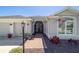 Charming front entrance with a brick walkway, colorful landscaping, and a welcoming address plaque at 6083 Delphina Loop, The Villages, FL 32163