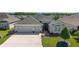 Attractive single-story home with a two-car garage, manicured lawn, and brick walkway leading to the front entrance at 6083 Delphina Loop, The Villages, FL 32163