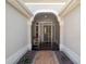 Inviting front porch with an arched entry, screen door, brick flooring and decorative gravel at 6083 Delphina Loop, The Villages, FL 32163
