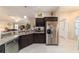 Well-lit kitchen featuring stainless steel appliances and dark wood cabinetry at 6083 Delphina Loop, The Villages, FL 32163