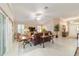 Open-plan living room featuring a leather sofa, tile floors, and bright natural light at 6083 Delphina Loop, The Villages, FL 32163