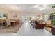 Open-concept living and dining area with sliding glass doors, modern furnishings, and neutral color palette at 6083 Delphina Loop, The Villages, FL 32163