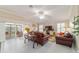Living room featuring tile flooring, comfortable seating, and bright, natural lighting at 6083 Delphina Loop, The Villages, FL 32163