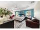 Main bedroom with blue accent wall, tray ceiling, carpet flooring, and bright natural light at 6083 Delphina Loop, The Villages, FL 32163