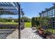 Paver patio with pergola, mature landscaping, and view of the beautifully maintained backyard at 6083 Delphina Loop, The Villages, FL 32163