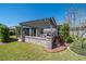 A well-manicured lawn leads up to a screened patio with pergola over a stone base at 6083 Delphina Loop, The Villages, FL 32163