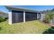 View of the screened in back patio with pergola detailing the lawn and garden at 6083 Delphina Loop, The Villages, FL 32163