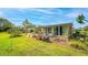 Landscaped backyard featuring a lawn, garden, and screened-in sunroom at 710 Dolphin Dr, Tavares, FL 32778