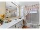 Bathroom featuring a single sink vanity, shower-tub combo, and palm tree decorations at 710 Dolphin Dr, Tavares, FL 32778