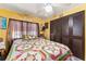 This bedroom features a patchwork quilt, ceiling fan, and closet at 710 Dolphin Dr, Tavares, FL 32778