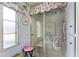This is a glass enclosed shower with towels and decorative seashell valance at 710 Dolphin Dr, Tavares, FL 32778