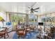Bright sunroom featuring large windows with lake view and a ceiling fan at 710 Dolphin Dr, Tavares, FL 32778
