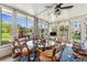 Bright sunroom featuring large windows with lake view, ceiling fan and glass top table at 710 Dolphin Dr, Tavares, FL 32778