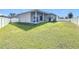 Picture of the back of the house with a spacious, well-maintained lawn, and a cozy covered patio at 717 Robin Ct, Kissimmee, FL 34759